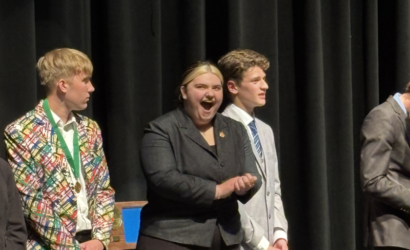 Darby Frei reacts on stage during a Speech Section Tournament awards ceremony.