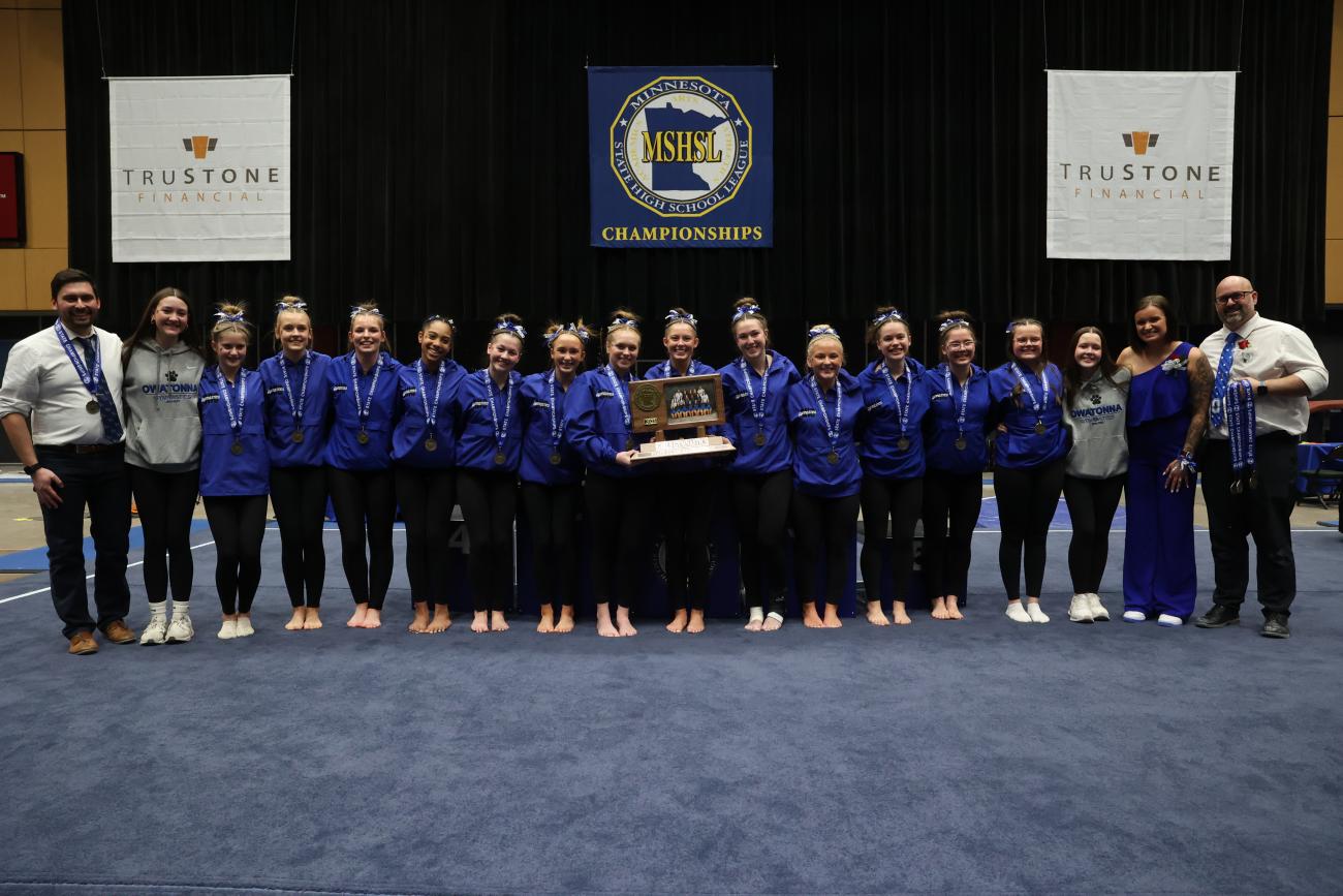 The 2025 Owatonna Girls Gymnastics Team with its state championship trophy.