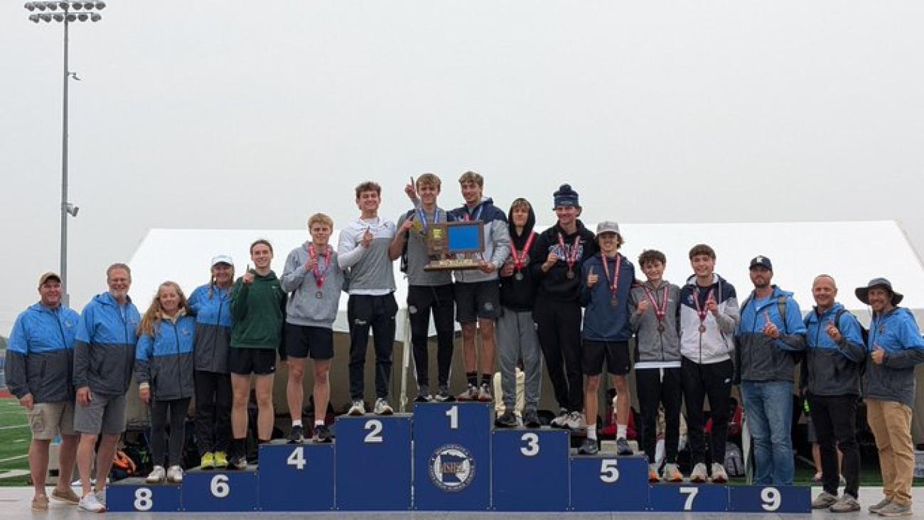 Becker Boys Track and Field team on MSHSL podium with first-place trophy