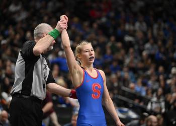 Simley's Charli Raymond's hand is raised after a wrestling victory.